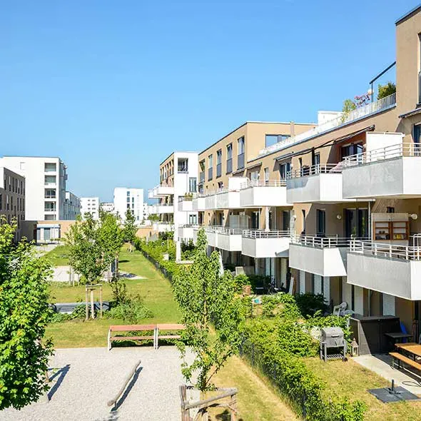 Modern flat development with green open space and clear blue sky